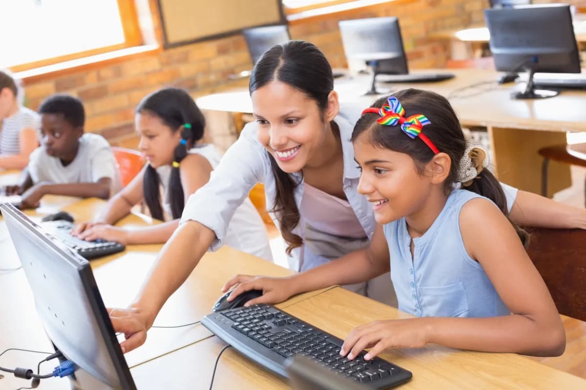 Children learning English on computers in a classroom